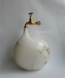 Beeld Druppel van albast met koperen kraan